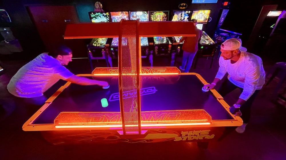 Playing air hockey at Time Rift Arcade